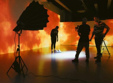 Mann steht vor flammender Kulisse und wird dabei gefilmt.